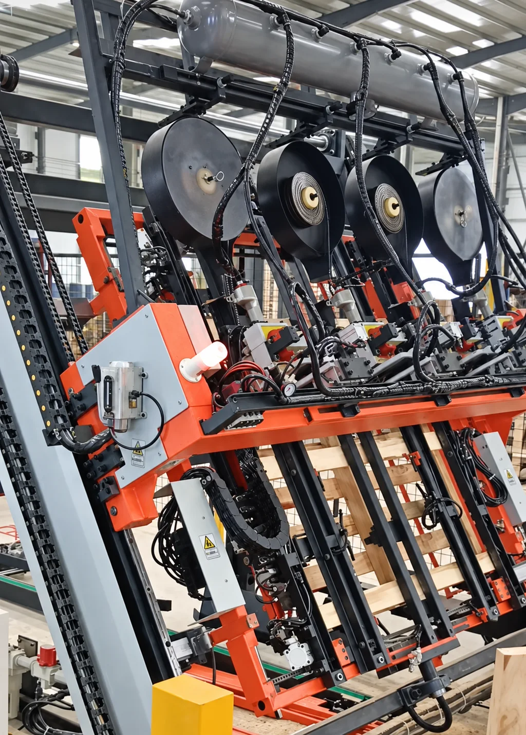 Multiple large nail reels above the nailing stations of a pallet machine